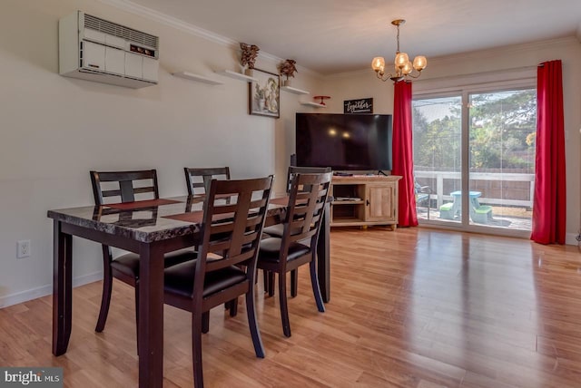 dining space with light hardwood / wood-style floors, a wall mounted AC, ornamental molding, and a chandelier