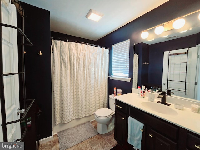 full bathroom with vanity, shower / tub combo with curtain, and toilet