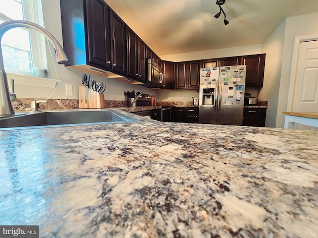 kitchen featuring stainless steel appliances, dark brown cabinets, and sink