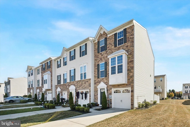 multi unit property with a front lawn and a garage