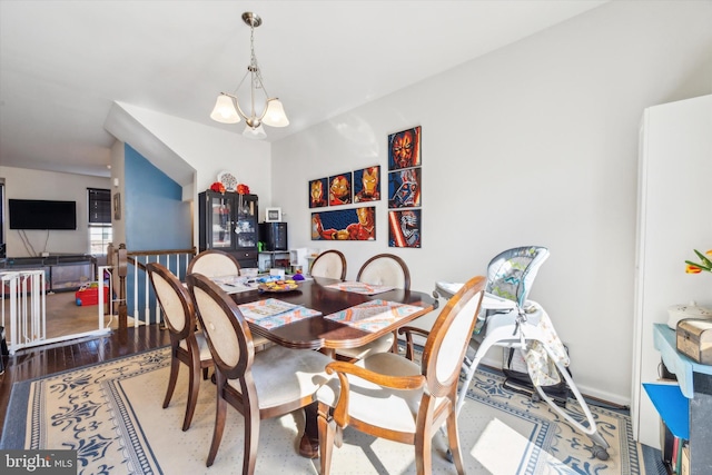 dining space featuring hardwood / wood-style flooring and a chandelier