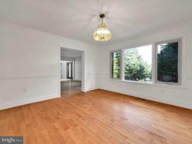 empty room featuring ornamental molding and light hardwood / wood-style flooring