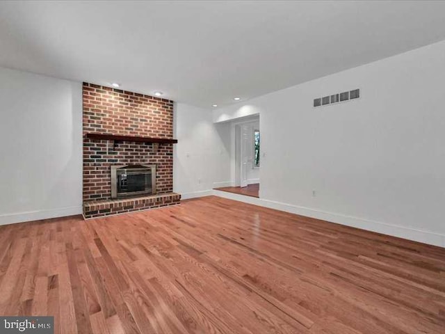 unfurnished living room featuring wood-type flooring and a fireplace