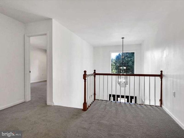 hallway featuring carpet floors and a chandelier