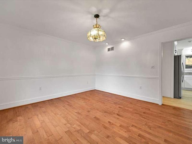 spare room featuring crown molding and wood-type flooring