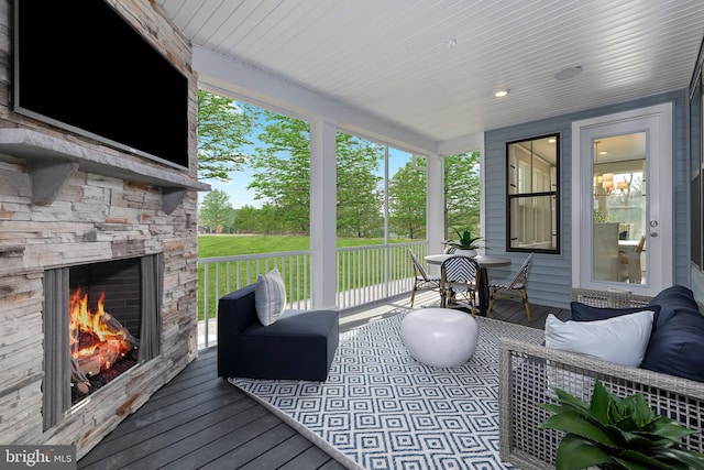 wooden terrace with an outdoor stone fireplace