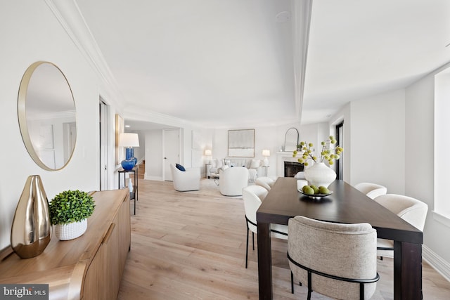 dining room featuring crown molding and light wood-type flooring