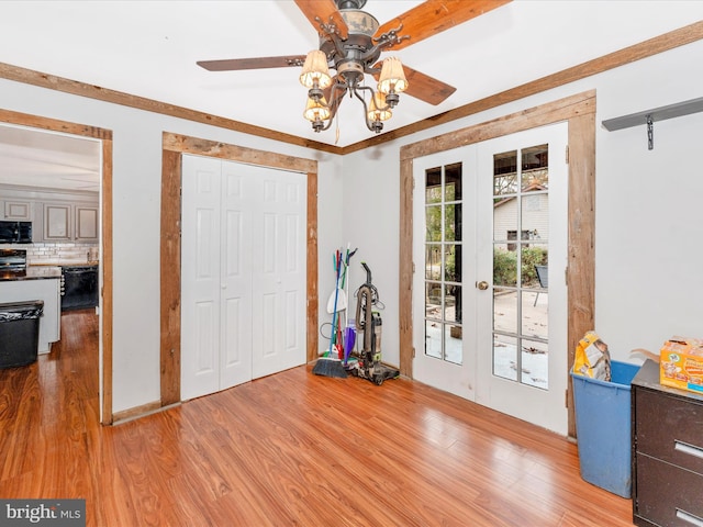 interior space with ornamental molding, ceiling fan, and light hardwood / wood-style flooring