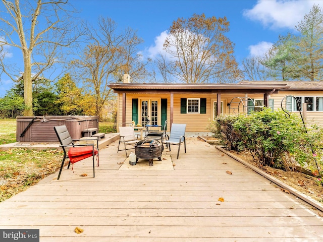 wooden deck featuring a hot tub and a fire pit