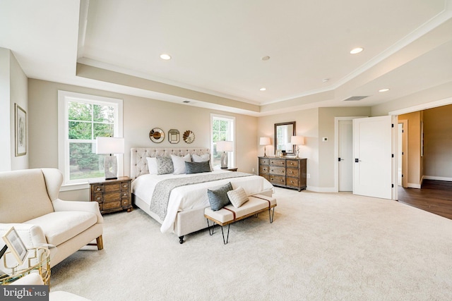 bedroom with crown molding, carpet floors, and a tray ceiling