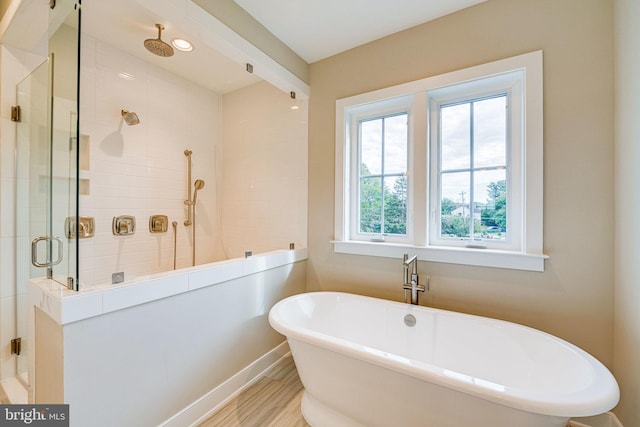 bathroom featuring shower with separate bathtub and hardwood / wood-style floors