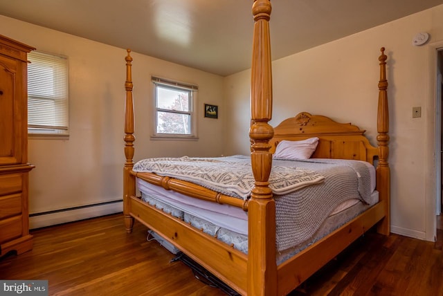 bedroom featuring a baseboard heating unit and dark hardwood / wood-style flooring