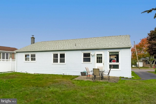 rear view of property with a patio and a yard