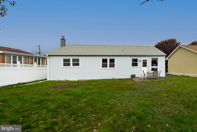 back of property featuring a patio area and a lawn