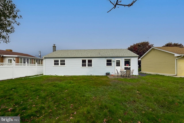 back of house with a patio and a lawn