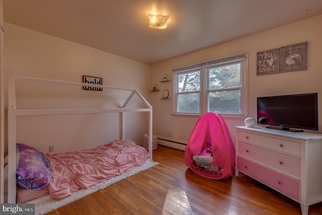 bedroom with hardwood / wood-style flooring and baseboard heating