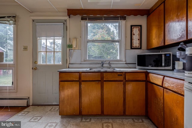 kitchen featuring light hardwood / wood-style flooring, sink, and a baseboard heating unit