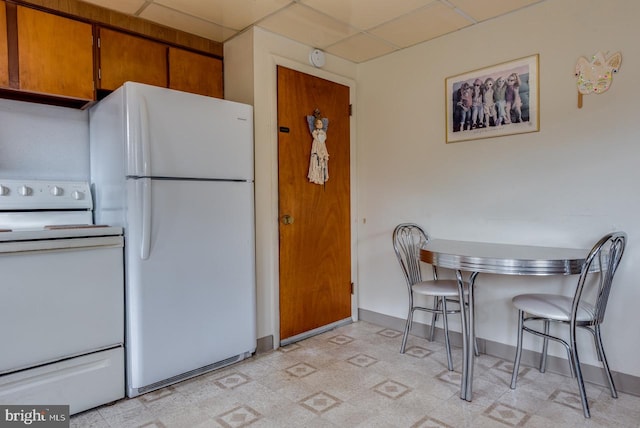 kitchen with white appliances and a drop ceiling