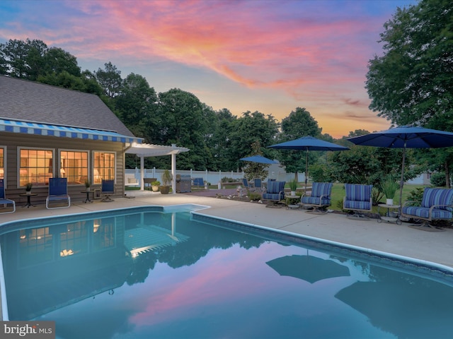 pool at dusk featuring a patio