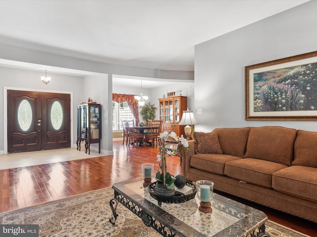 living room with a notable chandelier and light wood-type flooring