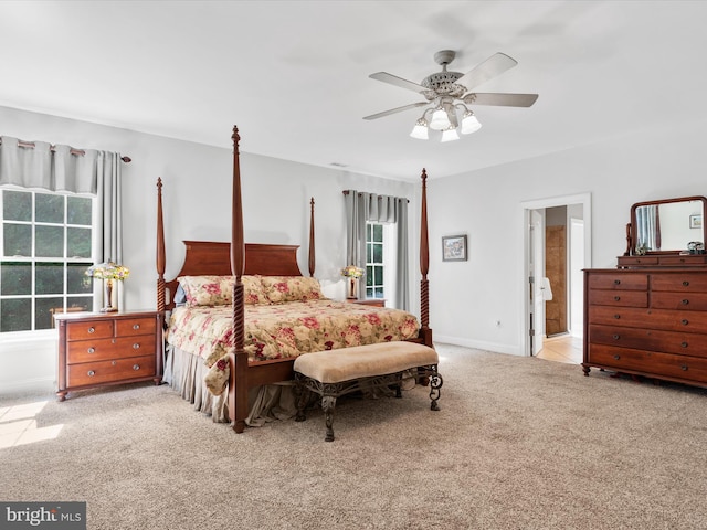 carpeted bedroom with ensuite bathroom and ceiling fan