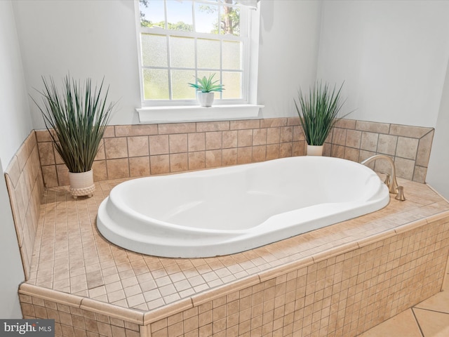 bathroom with tile patterned flooring and tiled bath