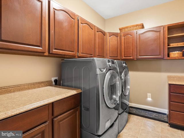 laundry room with cabinets, independent washer and dryer, and light tile patterned flooring