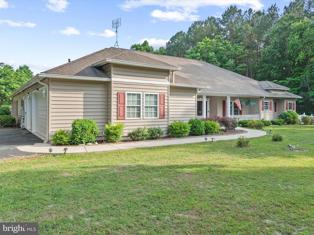 single story home featuring a garage and a front lawn