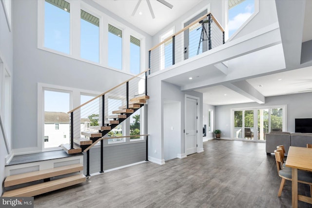 interior space featuring wood-type flooring, a towering ceiling, and ceiling fan