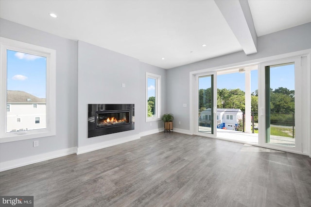 unfurnished living room with hardwood / wood-style floors and beamed ceiling