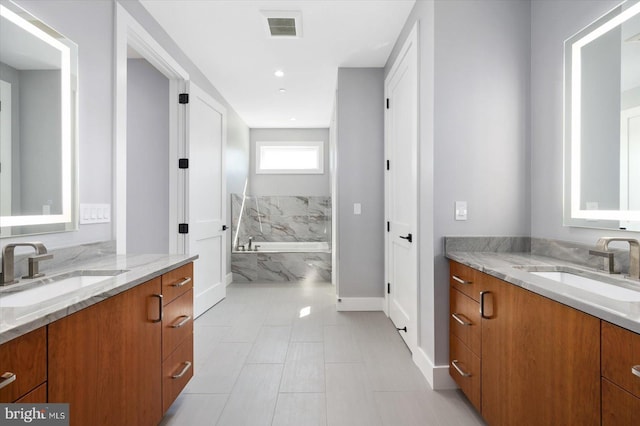 bathroom with vanity and tiled tub