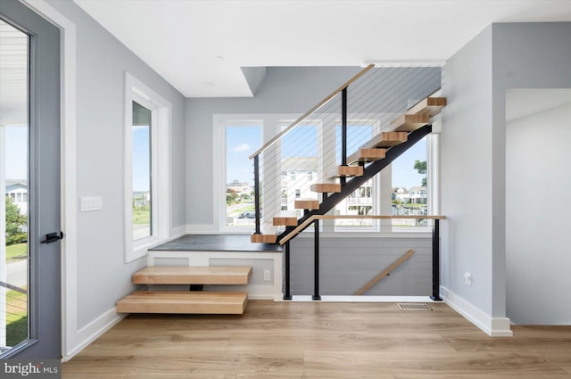 staircase featuring a healthy amount of sunlight and wood-type flooring