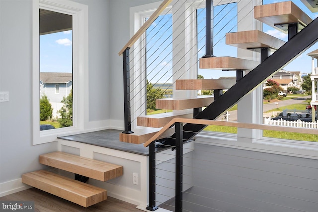 staircase with hardwood / wood-style floors and plenty of natural light