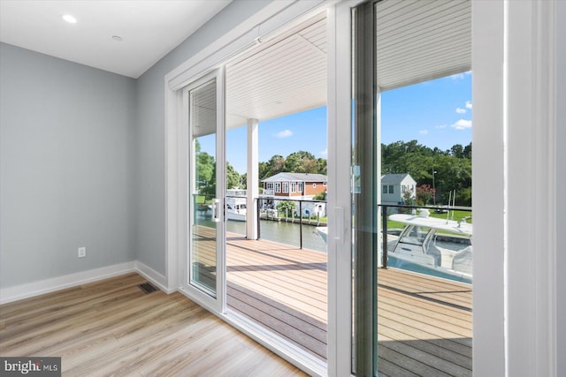 entryway with a water view, light hardwood / wood-style flooring, and a wealth of natural light