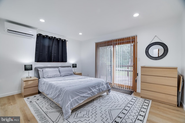 bedroom featuring an AC wall unit and light hardwood / wood-style flooring