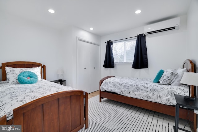 bedroom featuring an AC wall unit and a closet