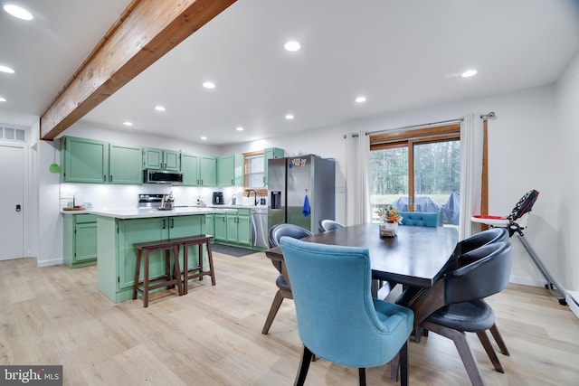 dining area with sink, beam ceiling, and light hardwood / wood-style flooring