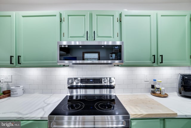 kitchen with appliances with stainless steel finishes and green cabinets