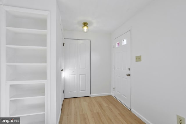 doorway with light hardwood / wood-style floors and built in features