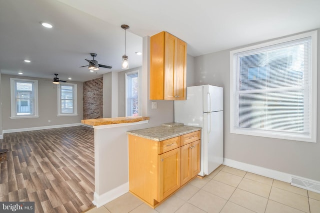 kitchen featuring a wealth of natural light, light hardwood / wood-style flooring, white fridge, and ceiling fan