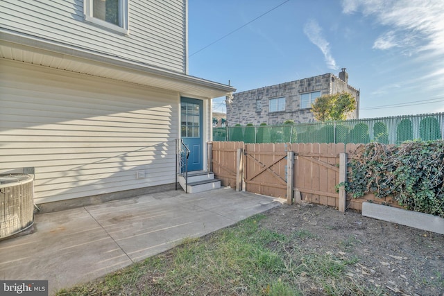 view of yard with central AC and a patio