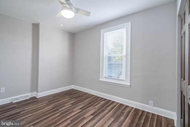 empty room featuring ceiling fan and dark hardwood / wood-style flooring