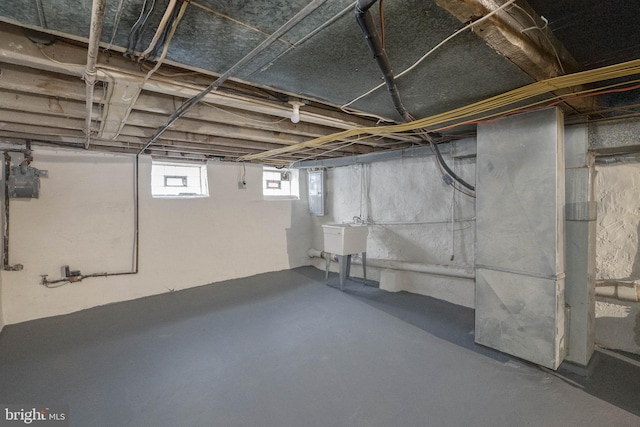 basement featuring electric panel and sink