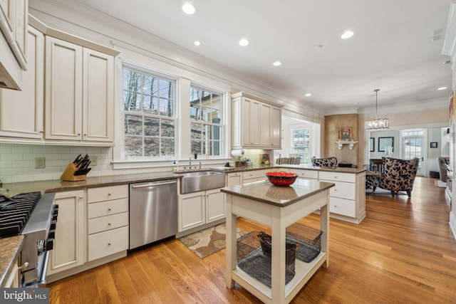 kitchen with sink, dishwasher, pendant lighting, and light wood-type flooring