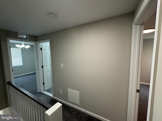 corridor with carpet and an inviting chandelier