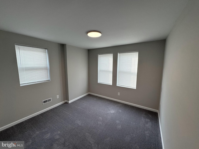 empty room with dark colored carpet