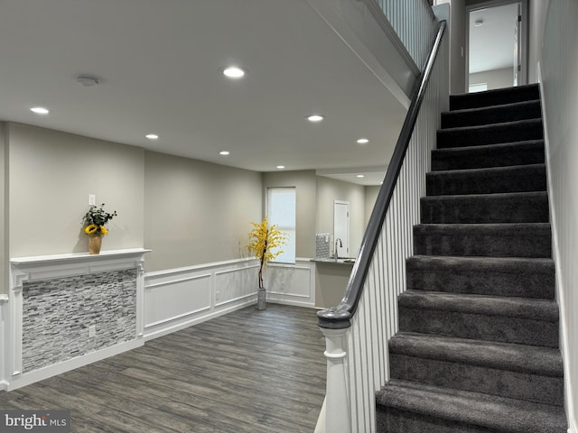 stairs with hardwood / wood-style flooring and sink