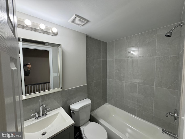 full bathroom featuring backsplash, vanity, tile walls, toilet, and tiled shower / bath