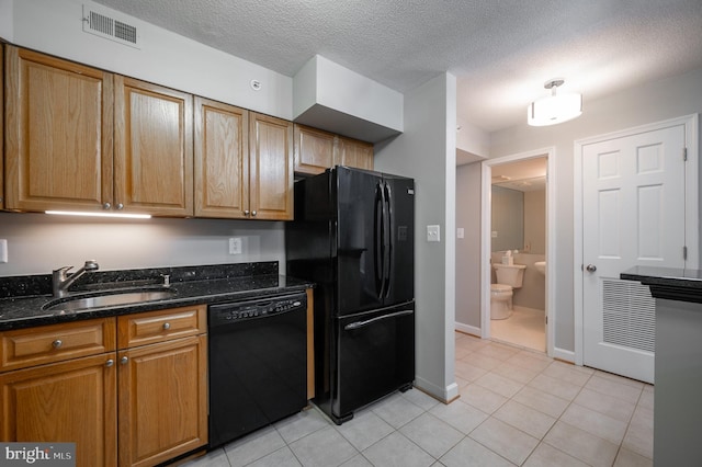 kitchen with light tile patterned flooring, black appliances, sink, and dark stone counters