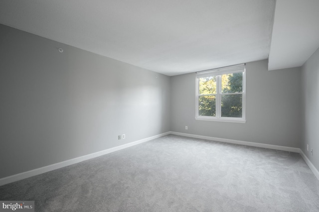 carpeted empty room featuring baseboards